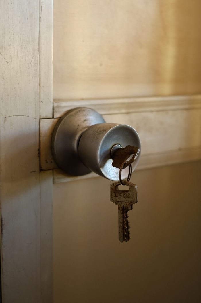 who-we-are A key inserted in a metal door knob, symbolizing security and entry.